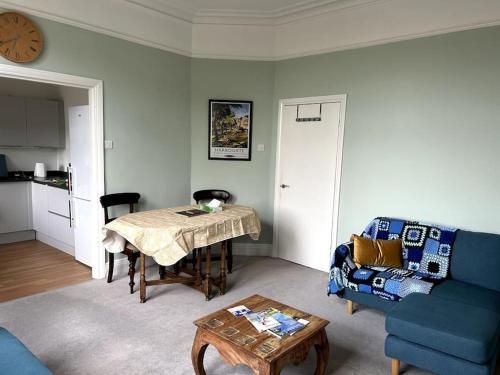 a living room with a table and a blue couch at Suze's Stays in Harrogate