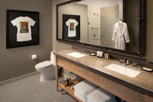 a bathroom with a sink and a toilet and a mirror at Hotel ZaZa Austin in Austin