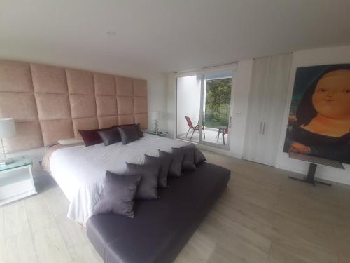 a bedroom with a large bed and a couch at Mirador samsara in La Calera