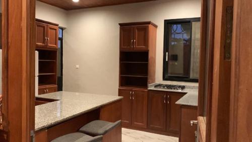 Una cocina con gabinetes de madera y encimera. en At Home, en Douala