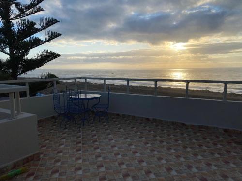 een balkon met een tafel en stoelen en uitzicht op de oceaan bij cap beddouza in Meddouza