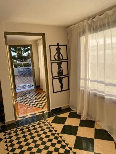 een kamer met een geruite vloer en een raam bij cap beddouza in Meddouza