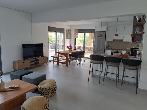 a kitchen and living room with a table and chairs at Villa Milan 1 mit Padelplatz in Kos Town