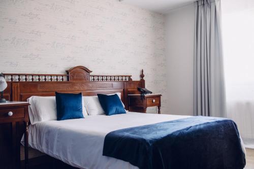 a bedroom with a large bed with blue pillows at Hotel Cueli in Viveda
