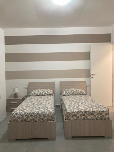 two beds sitting next to each other in a bedroom at Passalacqua House in Cinisi
