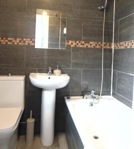 uma casa de banho com um lavatório, uma banheira e um WC. em Westland Road, Watford em Watford