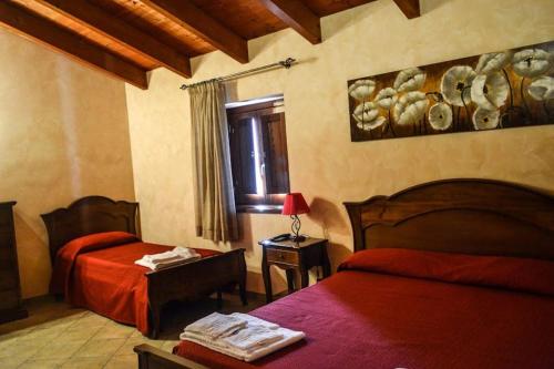 a bedroom with two beds and a window at Agriturismo U' Casinu dà Scala in Campora San Giovanni