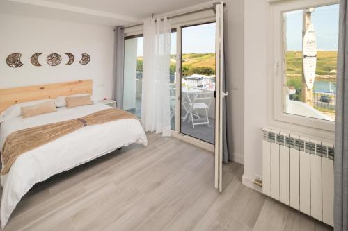 1 dormitorio con 1 cama y balcón con mesa en Precioso apartamento con vistas espectaculares, en Santander