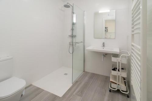 baño blanco con ducha y lavamanos en Precioso apartamento con vistas espectaculares, en Santander