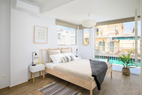 een witte slaapkamer met een bed en een raam bij The H Experience - Urban 2BD Rooftop Athens Center in Athene