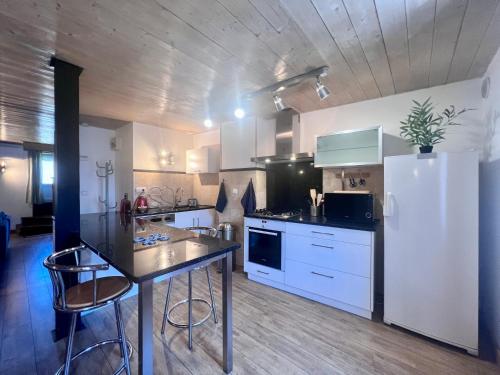 cocina con mesa y nevera blanca en Casa Montcalm - Spacieux - Brive Proche Gare/Centre, en Brive-la-Gaillarde