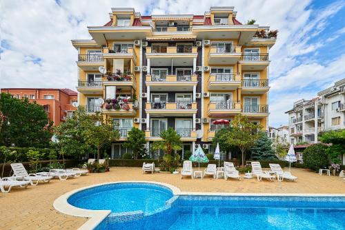 a hotel with a swimming pool in front of a building at Апартамент за гости Магнолия Резиденс in Sunny Beach