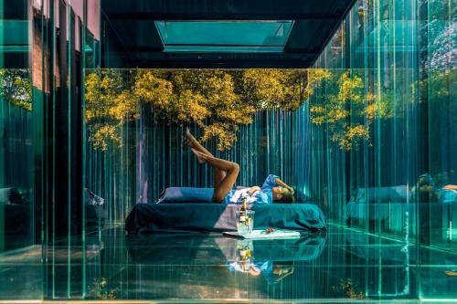 a woman laying on a bed in front of a building at Les Cols Pavellons in Olot