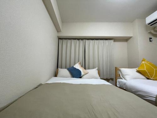 a small room with two beds and a window at Sunny Heights Osaki - Vacation STAY 14997 in Tokyo