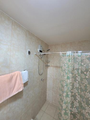 y baño con ducha y cortina de ducha. en Habitación con baño propio para 2 personas como máximo, en Lima