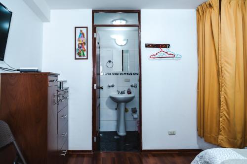 a bathroom with a sink and a shower with a mirror at Casa de Laura in Cusco