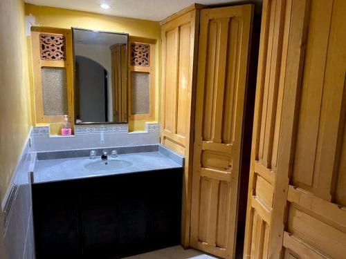 y baño con lavabo y espejo. en Hotel Niza Colonial, en Bogotá