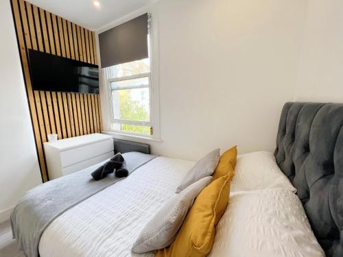 a bedroom with a bed with a teddy bear on it at Minet Gardens - Modern Centrally located - Suite 5 in London