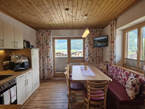 eine Küche mit einem Tisch und Stühlen im Zimmer in der Unterkunft Haus Höllerer in Uttendorf