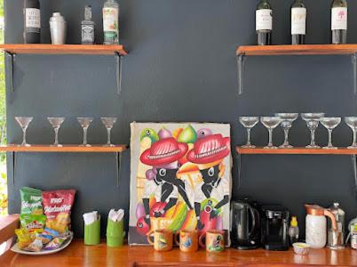 a counter top with wine glasses and a painting on it at Mecca in Puerto Viejo