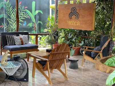a patio with chairs and a table and a sign at Mecca in Puerto Viejo