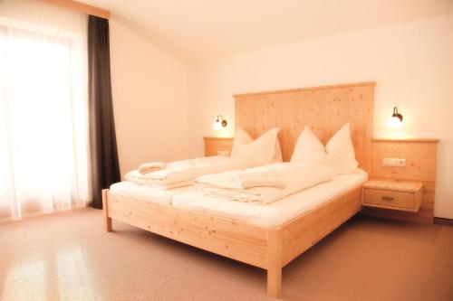 ein Schlafzimmer mit einem großen Bett mit weißen Kissen in der Unterkunft Appartements Stockinger in Großarl