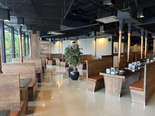 un restaurante con mesas de madera y una maceta en Mall Suites Hotel, en Bangkok