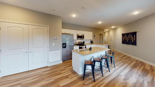 a kitchen with white cabinets and a island with bar stools at Viewpoint Condominiums in Pigeon Forge