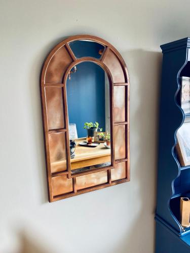 a mirror hanging on a wall with a table at The Grange in Admaston