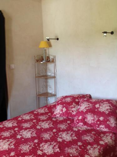 GagnièresにあるArdèche Mas de la châtaigneraie gîtes près de vallon pont d arcのベッドルーム1室(赤毛布とランプ付きのベッド1台付)