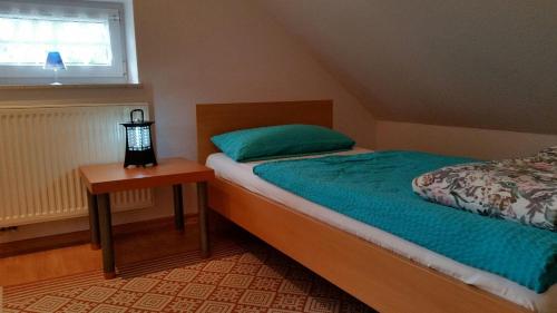 ein kleines Schlafzimmer mit einem Bett und einem Nachttisch in der Unterkunft Haus Schiffer - Ferienwohnung "Finja" in Rhauderfehn