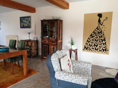 ein Wohnzimmer mit einem Stuhl und einem Tisch in der Unterkunft Haus Schiffer - Ferienwohnung "Finja" in Rhauderfehn