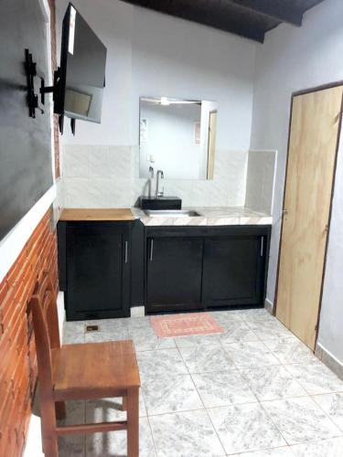 a kitchen with a sink and a mirror and a chair at Apart Belgrano in Puerto Iguazú