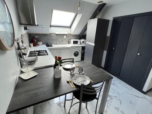 une cuisine avec une table et des chaises dans une cuisine dans l'établissement Logement studio, à Quintin