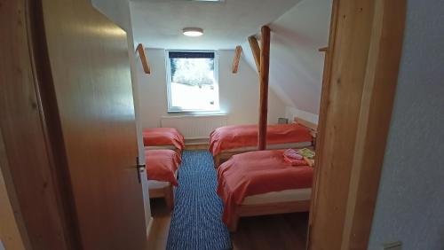 a room with three beds and a window at Haus Waldschänke in Erlbach