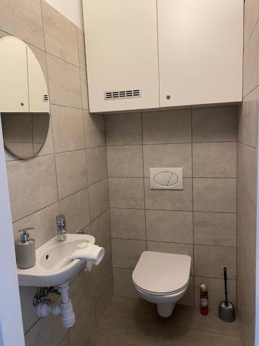 a bathroom with a sink and a toilet and a mirror at Moonshine Szeged in Szeged