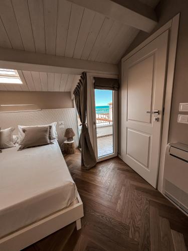 um quarto com uma cama e uma porta de vidro deslizante em B&B Palazzo Bruni - Dimora di Mare em Marina di San Vito