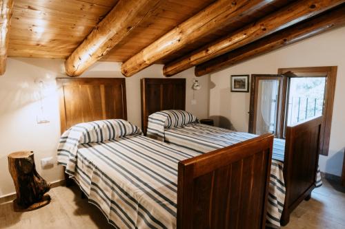 2 letti in una camera con soffitti in legno di Casa Bernardi Holiday home - Asolo ad Asolo