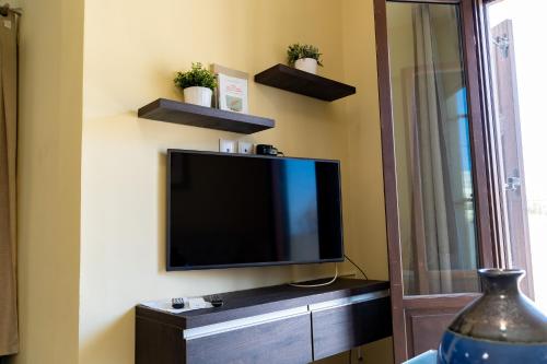 a flat screen tv sitting on a wall at Theoxenia Kasos Luxury Apartments in Panayía