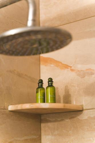 two green bottles sitting on a shelf under a sink at Theoxenia Kasos Luxury Apartments in Panayía