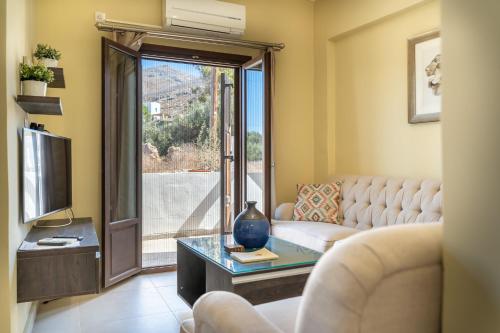 a living room with a couch and a tv at Theoxenia Kasos Luxury Apartments in Panayía