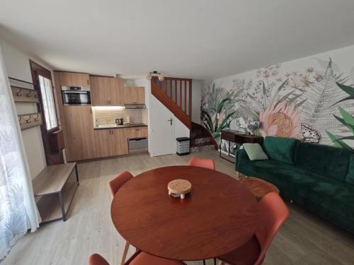 ein Wohnzimmer mit einem Tisch und einem grünen Sofa in der Unterkunft Le nid de l'île in Amboise