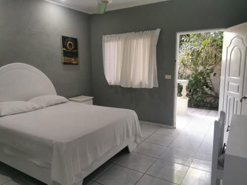 a bedroom with a white bed and a window at Hotel Cambri in Nagua