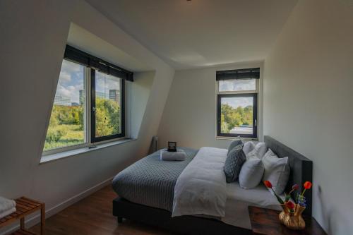 a bedroom with a bed and two windows at Brand new bright luxurious villa in Amsterdam! in Amsterdam