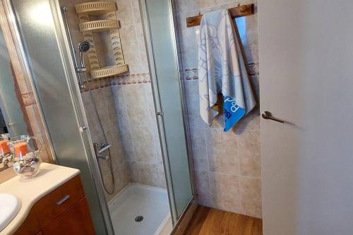 um chuveiro com uma porta de vidro ao lado de um lavatório em Bravaholidays-600-Mas Altaba em Terra Brava