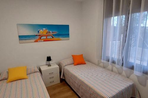 a bedroom with two beds and a window with a picture at Bravaholidays-600-Mas Altaba in Terra Brava