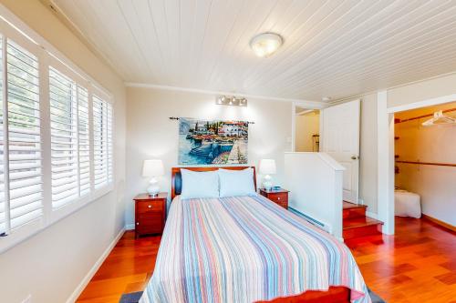 1 dormitorio con 1 cama, 2 mesitas de noche y 2 ventanas en Tranquil Haven Cottage Retreat, en San Rafael