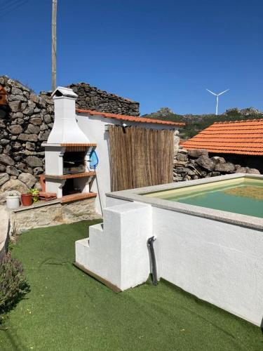 a house with a swimming pool and a stone wall at BezerreiraComVida-O refúgio do monte in Bezerreira