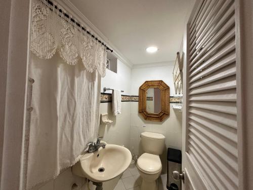 biała łazienka z toaletą i umywalką w obiekcie Apartamento Alvarez w mieście Cartagena de Indias