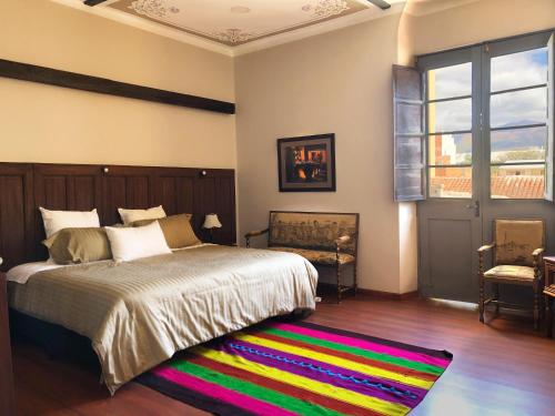 sypialnia z dużym łóżkiem i kolorowym dywanem w obiekcie Casona Gloria w mieście Tarija